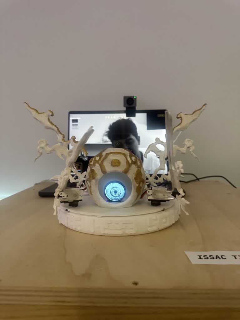 Exhibition setup with screen behind showing face detection feed and webcam mounted above